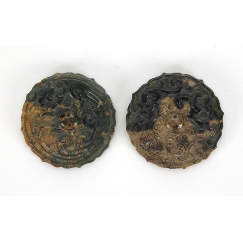 424 - Two Chinese circular jade discs with shaped edges, both carved with mythical creatures, 5.2cm in dia... 