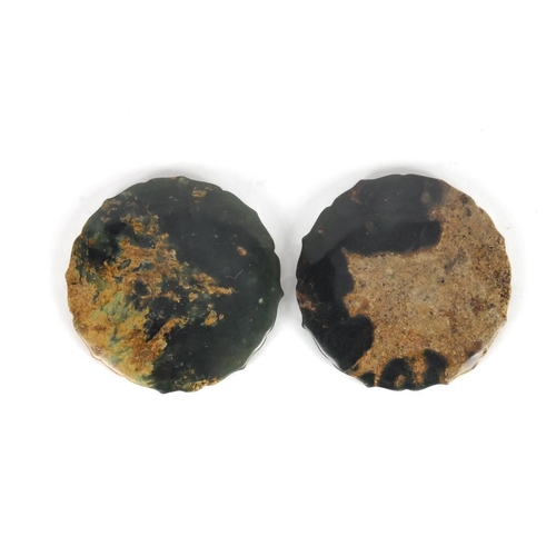 424 - Two Chinese circular jade discs with shaped edges, both carved with mythical creatures, 5.2cm in dia... 