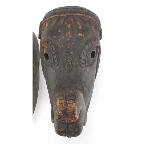 492 - Two African tribal carved wooden face masks, one of an elephant, the largest 29cm high