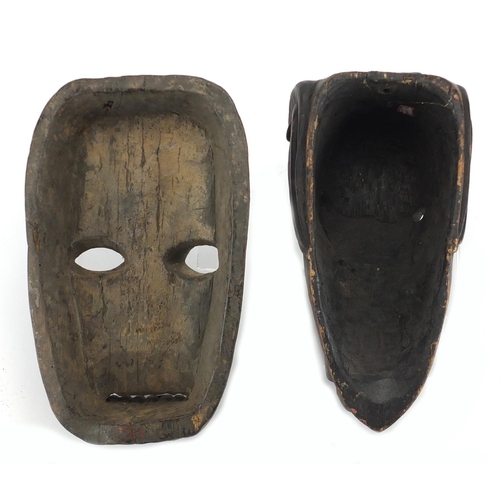 492 - Two African tribal carved wooden face masks, one of an elephant, the largest 29cm high