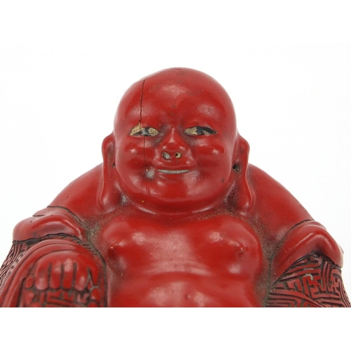 543 - Chinese Cinnabar lacquer figure of Buddha, raised on a hardwood stand, overall 7.5cm high