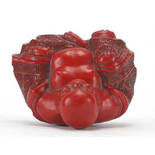 543 - Chinese Cinnabar lacquer figure of Buddha, raised on a hardwood stand, overall 7.5cm high