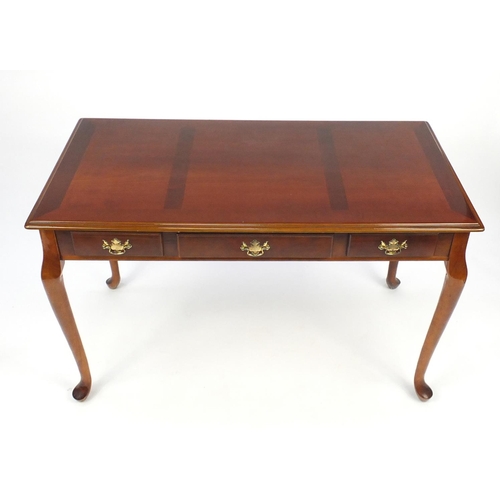 16 - Cross banded mahogany centre table fitted with three drawers, raised on cabriole legs, 77cm H x 121c... 
