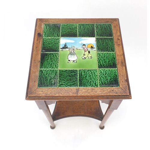 2031 - Arts & Crafts oak tile top occasional table with under tier, the central tile hand painted with two ... 