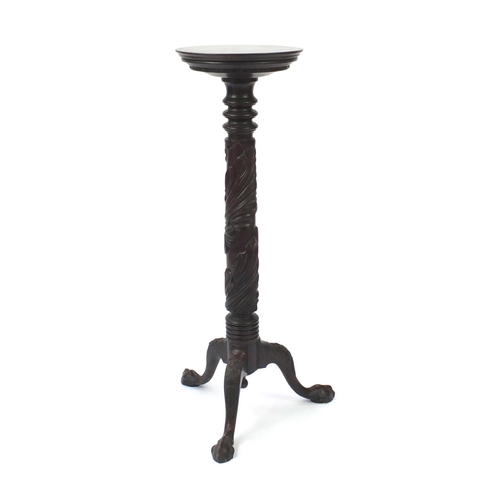 41 - Carved mahogany torchère with a tripod base and ball and claw feet, 105cm high