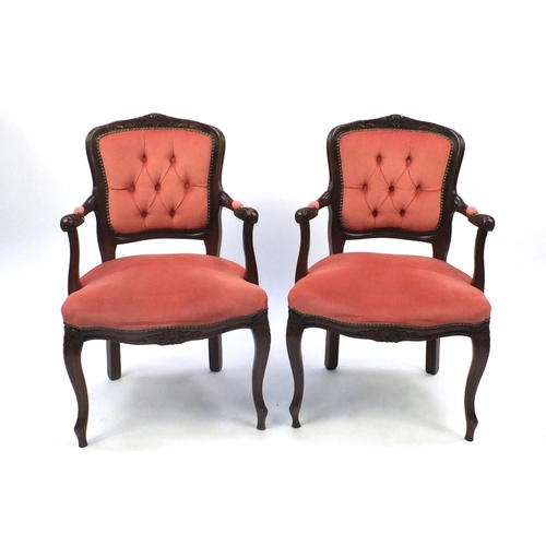 10 - Pair of French design carved mahogany open arm chairs, with pink buttonback upholstery