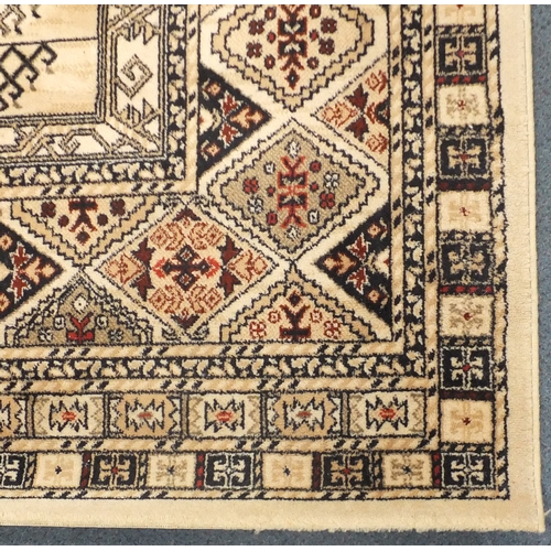 17 - Beige ground rug, with all over geometric design, approximately 290cm x 200cm