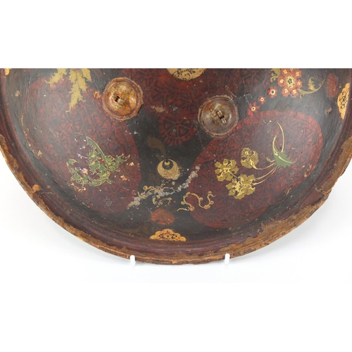 607 - Circular Islamic leather shield, hand painted with flowers, 33cm in diameter