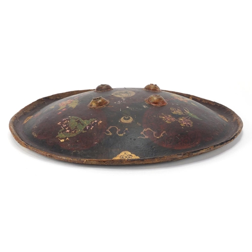 607 - Circular Islamic leather shield, hand painted with flowers, 33cm in diameter