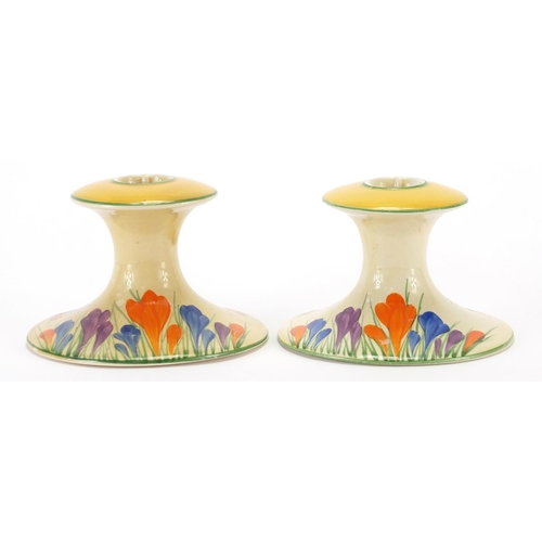 793 - Pair of Clarice Cliff Bizarre candlesticks, hand painted in the Crocus pattern, each 7.5cm high
