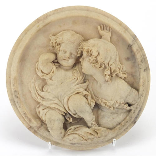 2187 - Circular classical marbleised panel, decorated in relief with young children, 18.5cm in diameter