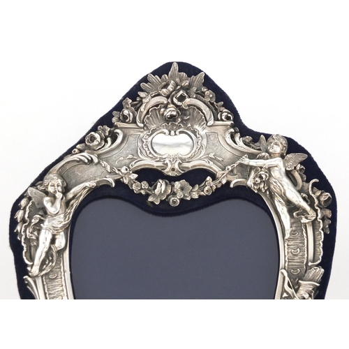 2534 - Modern silver easel photo frame, relief decorated with cupids and birds amongst flowers, 31cm high