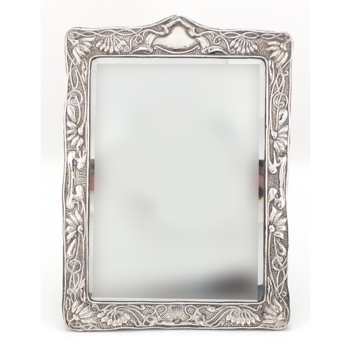 2534 - Modern silver easel photo frame, relief decorated with cupids and birds amongst flowers, 31cm high