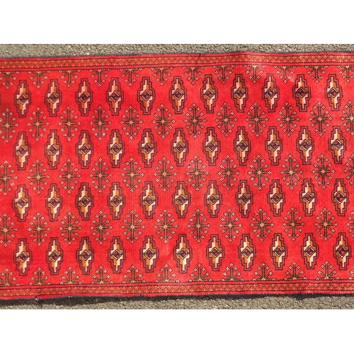 2078 - Rectangular Turkman carpet runner, having an all over repeat gull design onto a red ground, 332cm x ... 