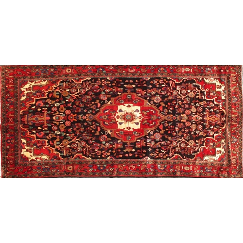 2009 - Rectangular Hamadan rug, having an all over stylised floral design onto a predominantly red and blac... 