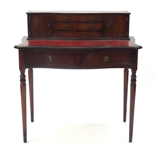 25 - Mahogany serpentine front ladies writing desk, with tooled leather insert and a series of drawers, 9... 