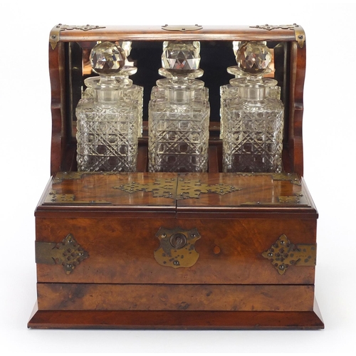 67 - Victorian walnut three bottle Tantalus with brass mounts, fitted interior and base drawer housing tw... 