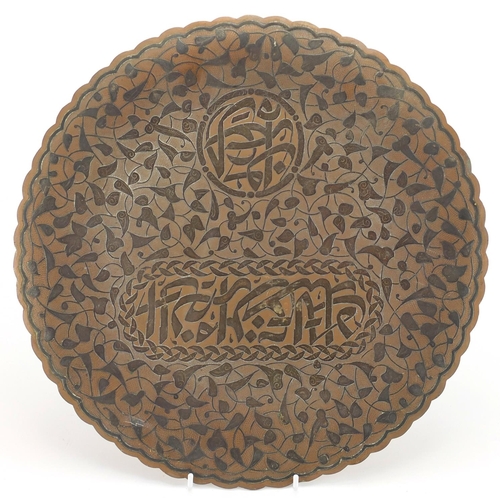583 - Cairoware brass three footed dish, with silver inlay decorated with script amongst stylised foliage,... 