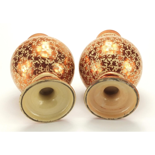 595 - Pair of Middle Eastern lustre pottery vases, hand painted with stylised motifs, each 25cm high