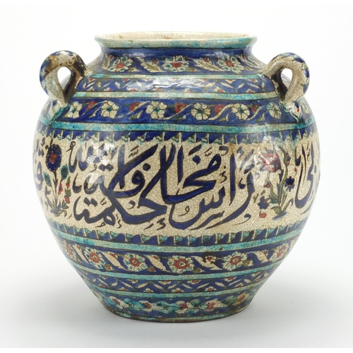 593 - Iznik pottery three handled vase, hand painted with a continuous band of script, within flower head ... 