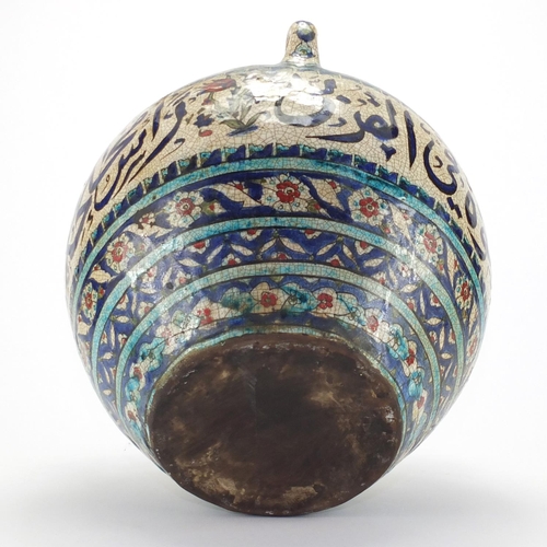 593 - Iznik pottery three handled vase, hand painted with a continuous band of script, within flower head ... 