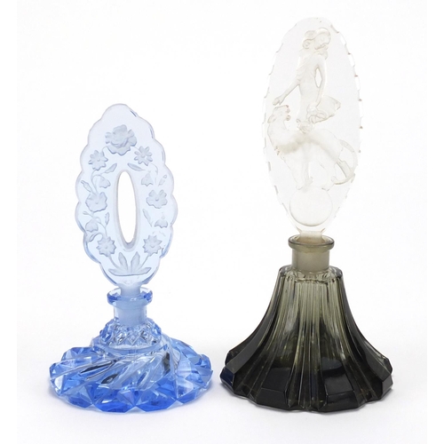 783 - Two cut glass scent bottles with etched stoppers, one with a girl and lion, indistinct marks to the ... 