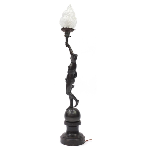46 - 19th century patinated bronze lamp with glass shade, modelled as a nude female holding a flaming tor... 