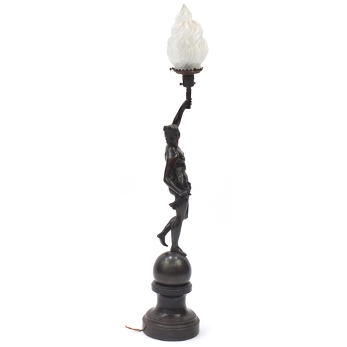 46 - 19th century patinated bronze lamp with glass shade, modelled as a nude female holding a flaming tor... 