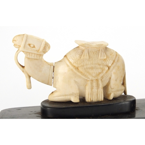 63 - Pair of African hardwood bookends, each mounted with a carved ivory camel, each 18.5cm wide