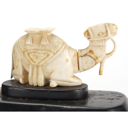 63 - Pair of African hardwood bookends, each mounted with a carved ivory camel, each 18.5cm wide