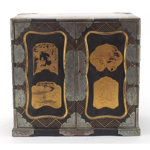 2161 - Japanese lacquer and gold dusted table cabinet, with a pair of doors opening to reveal an arrangemen... 