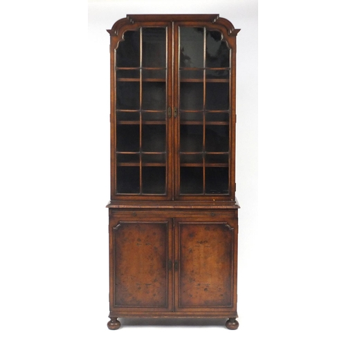 2003 - Walnut bookcase, with glazed doors above a brushing slide and cupboard door base, 188cm H x 79cm W x... 