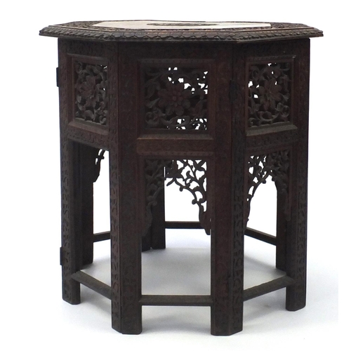 2076 - Indian hardwood octagonal folding table profusely carved and pierced with flowers, 56.5cm high x 55c... 