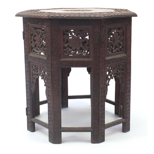 2076 - Indian hardwood octagonal folding table profusely carved and pierced with flowers, 56.5cm high x 55c... 