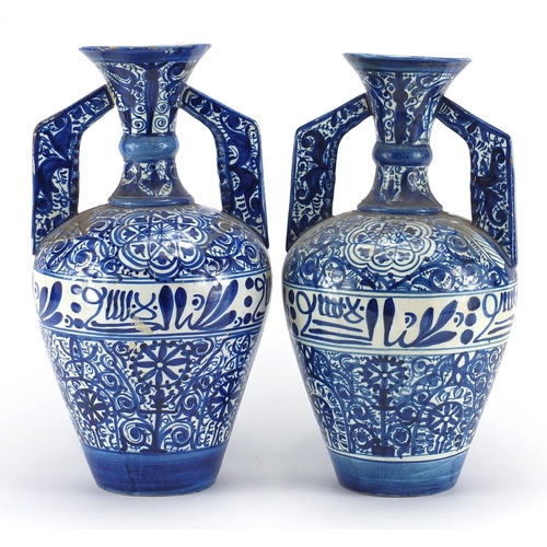 596 - Pair of Middle Eastern pottery vases, each with twin handles, both hand painted with script and flow... 