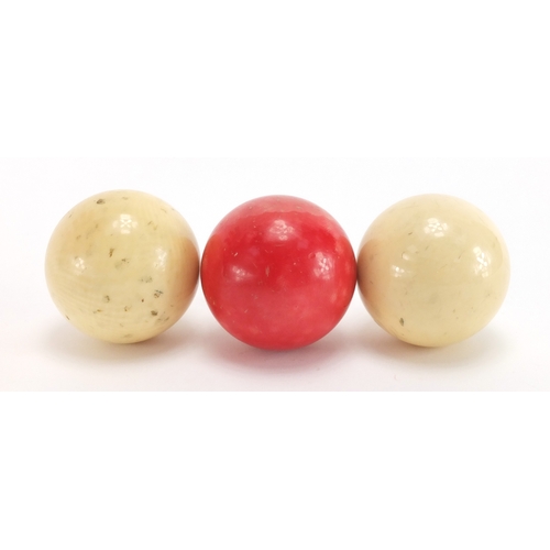 15 - Three turned ivory billiard balls including one stained red, housed in a Burroughes & Watts Ltd, eac... 