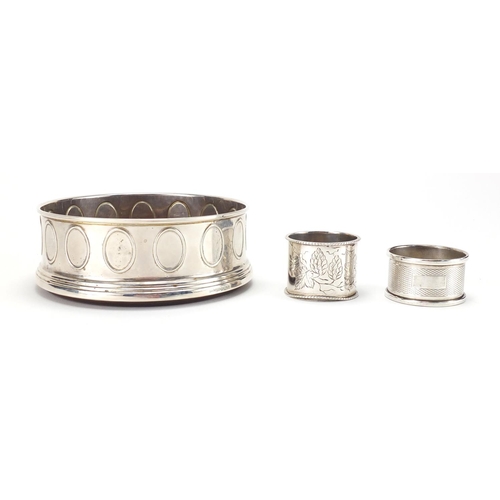 2541 - Modern circular silver wine coaster and two silver napkin rings, the coaster 12.5cm in diameter