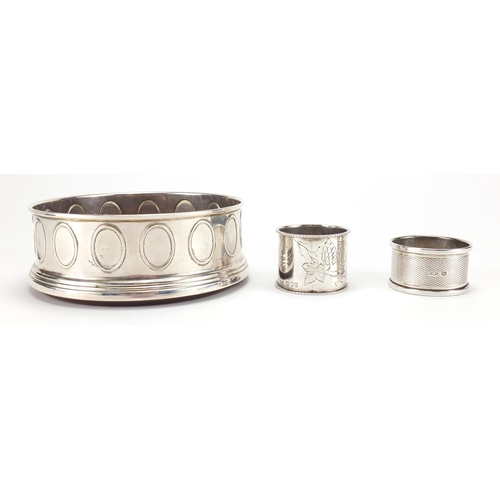 2541 - Modern circular silver wine coaster and two silver napkin rings, the coaster 12.5cm in diameter