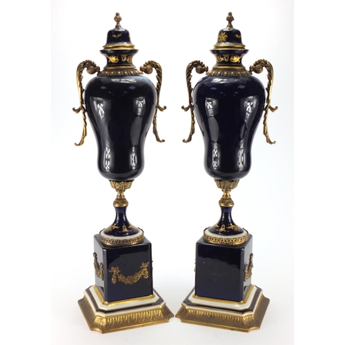 2323 - Pair of ornate Limoges porcelain lidded vases, with gilt metal twin handles, each decorated with a p... 