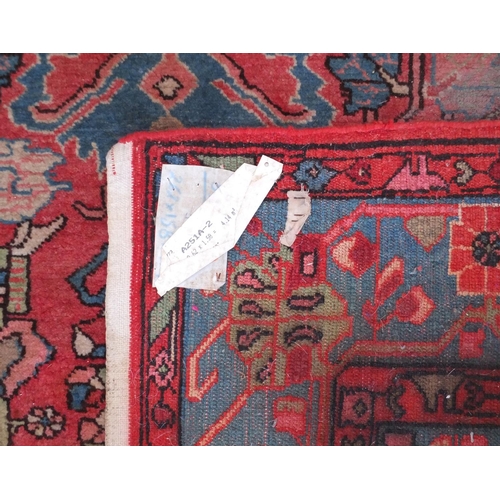 647 - Persian Serapi rug, having an all over stylised floral disign onto a red and blue ground, 260cm x 15... 