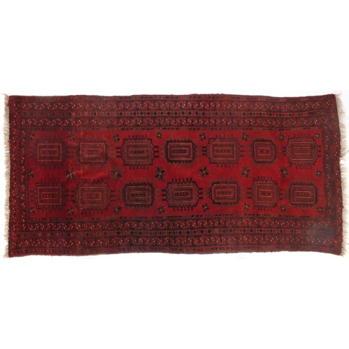 10 - Red ground rug with all over geometric design, 210cm x 108cm