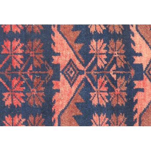 23 - Red and blue ground rug with all over geometric design, 170cm x 105cm