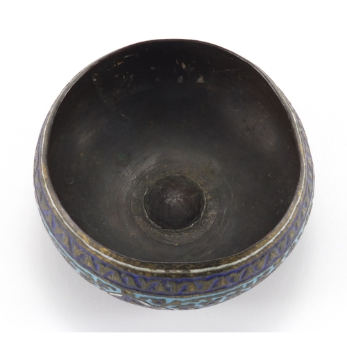 579 - Islamic copper bowl, enamelled with flowers amongst foliate motifs, 11cm in diameter