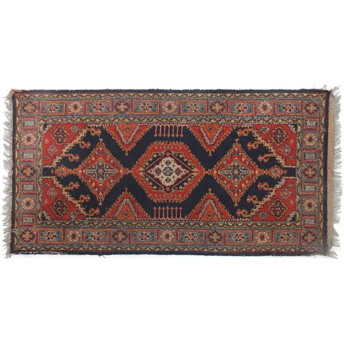 26 - Rectangular rug with all over geometric design, 128cm x 67cm