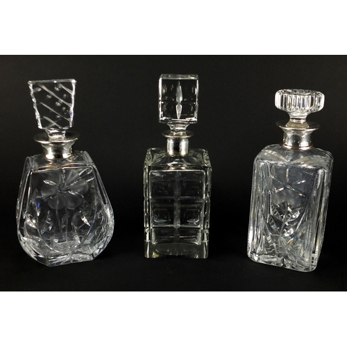 2190 - Three cut glass decanters, with silver collars including two with a flower design, the largest 25.5c... 