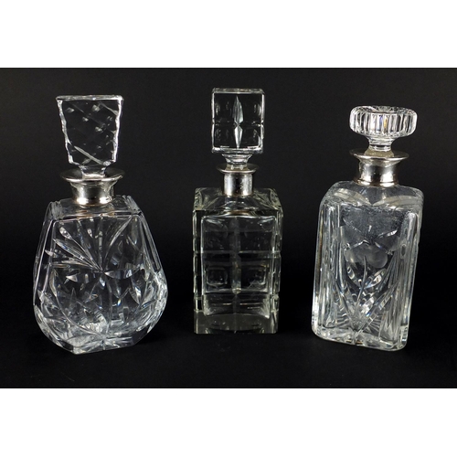 2190 - Three cut glass decanters, with silver collars including two with a flower design, the largest 25.5c... 