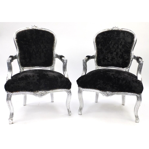 4 - Pair of ornate open armchairs, with painted silver frame and black velvet button back upholstery
