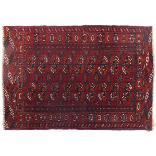 14 - Tekke Turkmen rug woven having two rows of nine guls on a brick red ground within corresponding bord... 