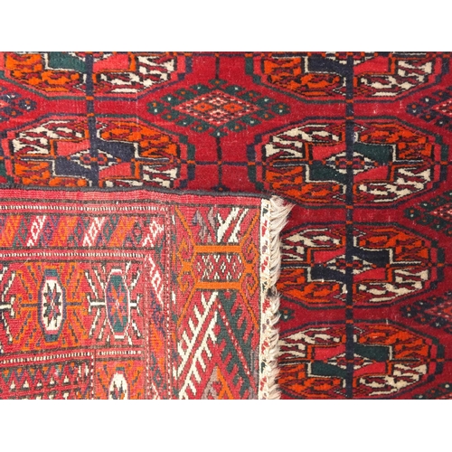 14 - Tekke Turkmen rug woven having two rows of nine guls on a brick red ground within corresponding bord... 