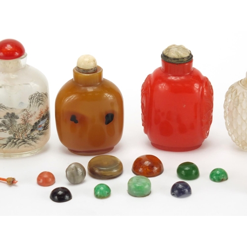 689 - Seven Chinese hardstone and glass snuff bottles together with a group of stoppers, including reverse... 